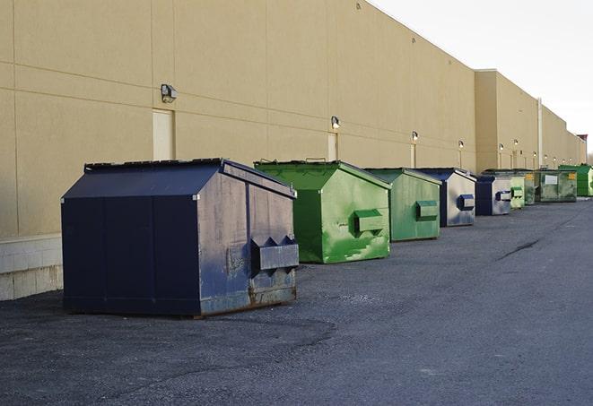 construction workers loading debris into dumpsters on a worksite in Dallas, GA